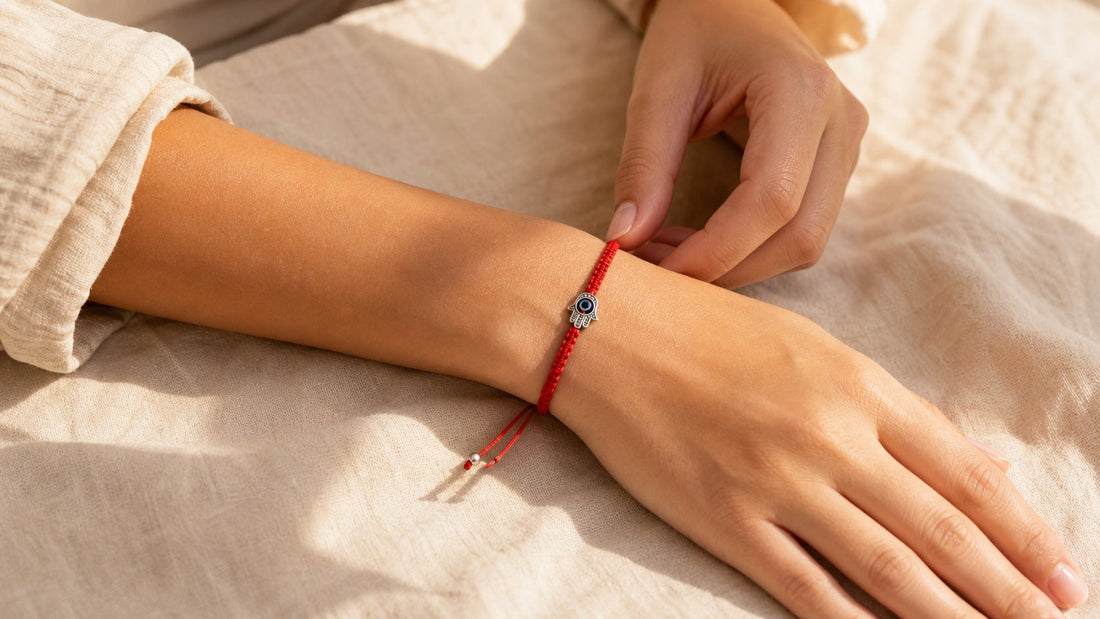 Woman adjusting a red Hamsa hand string bracelet on her left wrist