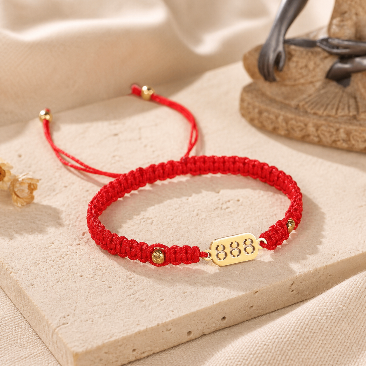 888 Angel Number Bracelet angled tabletop view with red braided cord and gold accents