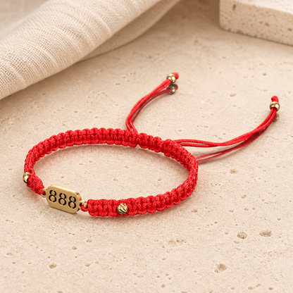 888 Angel Number Bracelet angled detail showing the red braid, gold beads and 888 plate