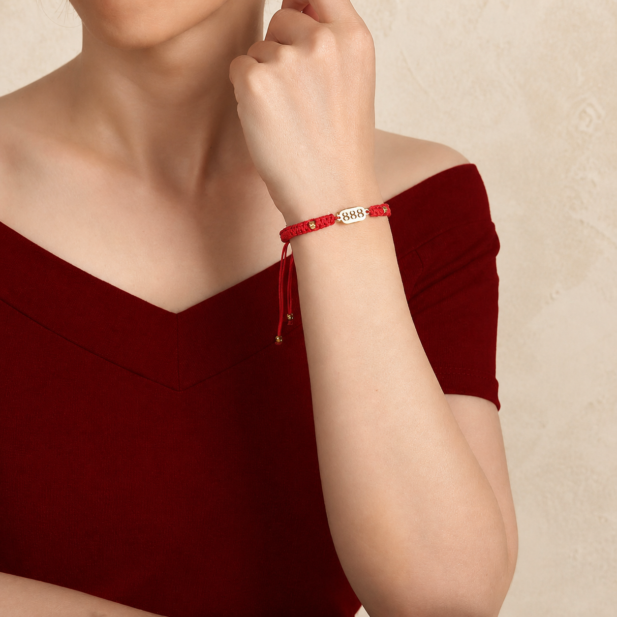 888 Angel Number Bracelet worn by a model with red braided cord and gold 888 plate