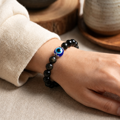 Black obsidian evil eye bracelet shown worn on one wrist
