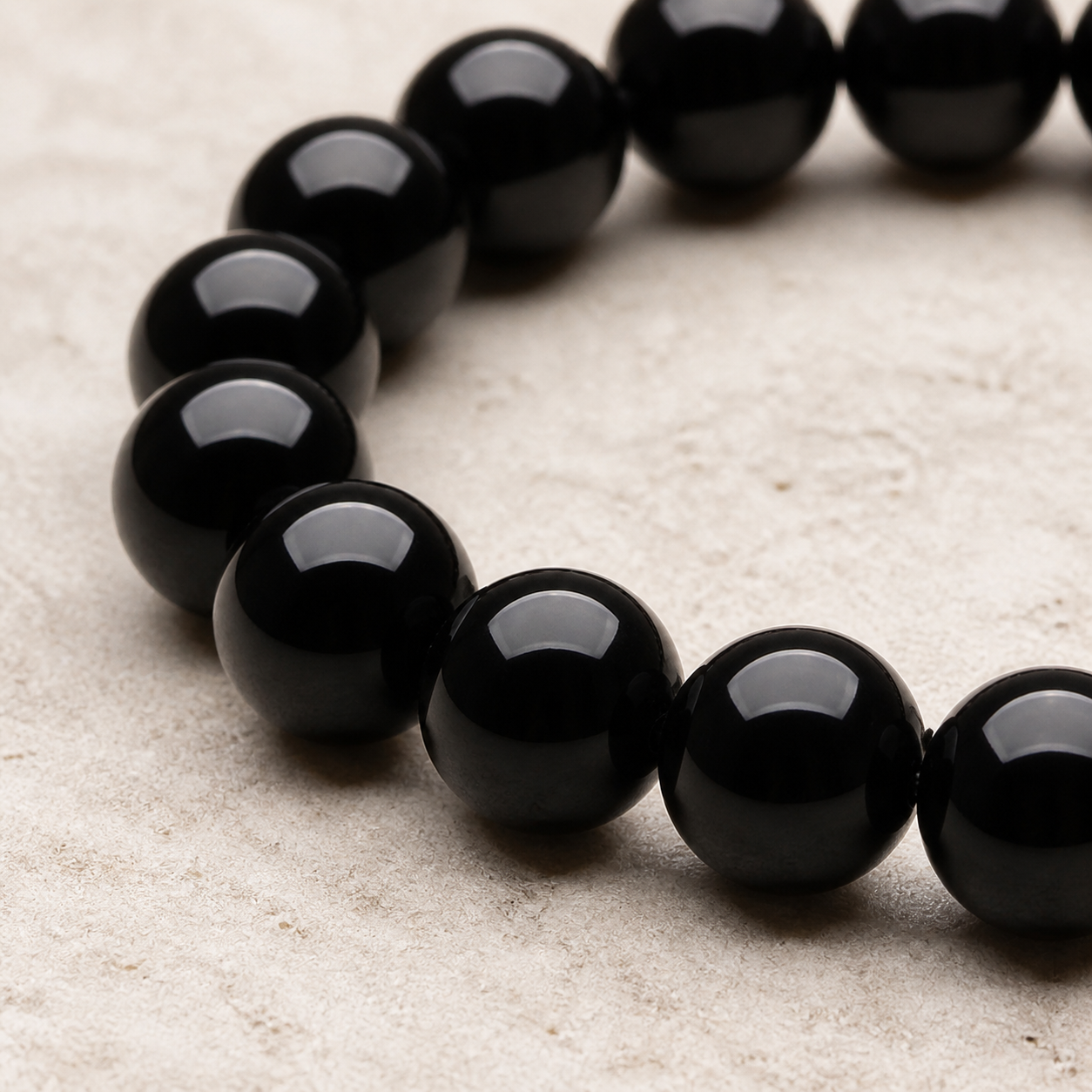 Close-up of glossy round black tourmaline beads and elastic construction