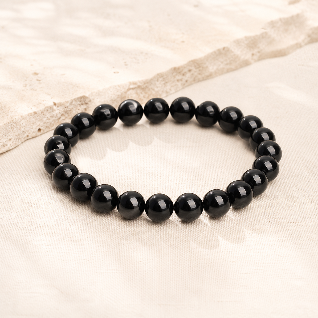 Black tourmaline bead bracelet on warm ivory linen