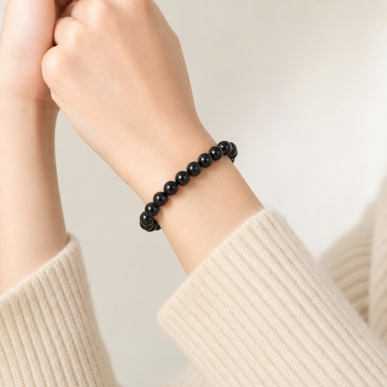 Black tourmaline bead bracelet shown worn on one wrist