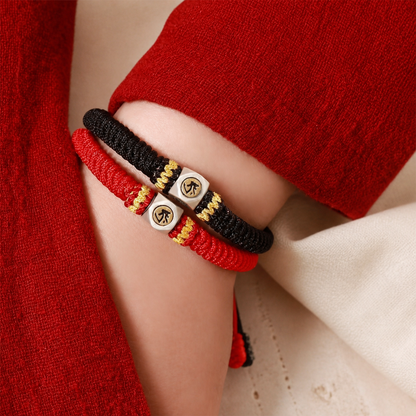 Red and black Chinese zodiac guardian rope bracelets worn on a wrist