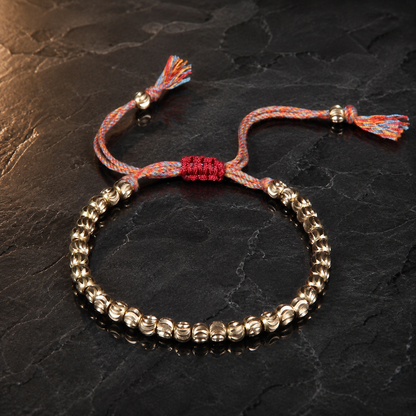 Copper Bead Bracelet dramatic reflective view with carved beads and red woven clasp