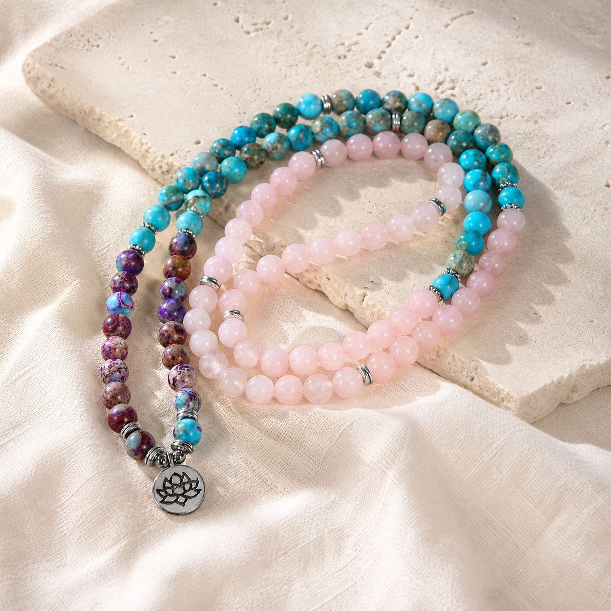 Lotus of Calm mala strands arranged on ivory stone