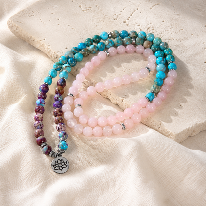 Lotus of Calm mala strands arranged on ivory stone