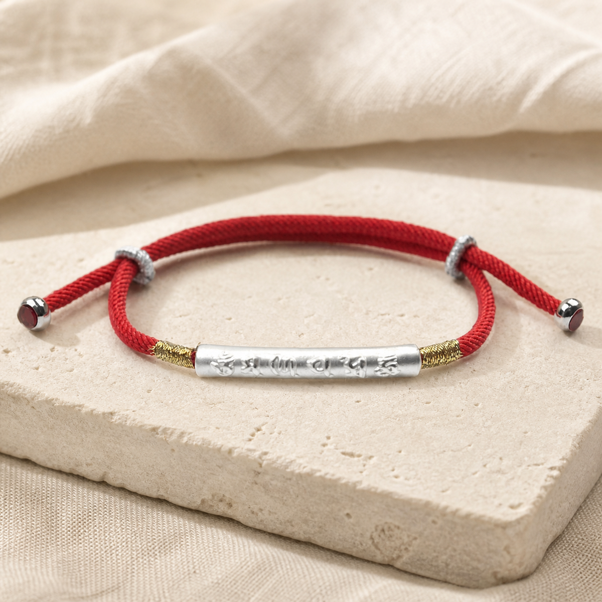 Red string bracelet with silver engraved tube and gold accent sections